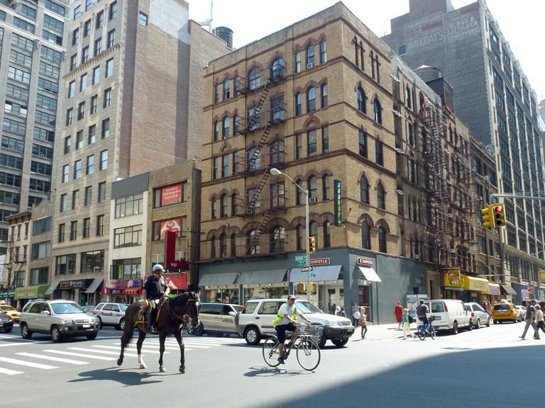 Ein berittener Polizist überquert am 17.08.2013 die Kreuzung Seventh Avenue und 26th Street in Chelsea, New York City.