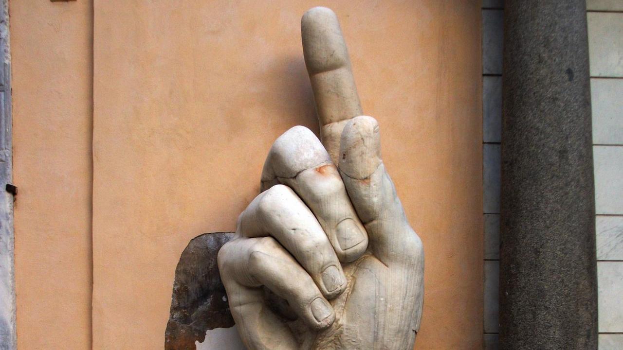 Die marmorne Hand der kolossalen Statue Kaiser Konstantins in Rom mit erhobenem Zeigefinger Die marmorne Hand der kolossalen Statue Kaiser Konstantins in Rom mit erhobenem Zeigefinger