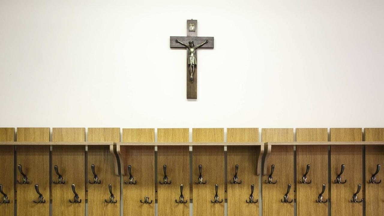 Ein Kruzifix hängt über einer Garderobe Ein Kruzifix hängt über einer Garderobe