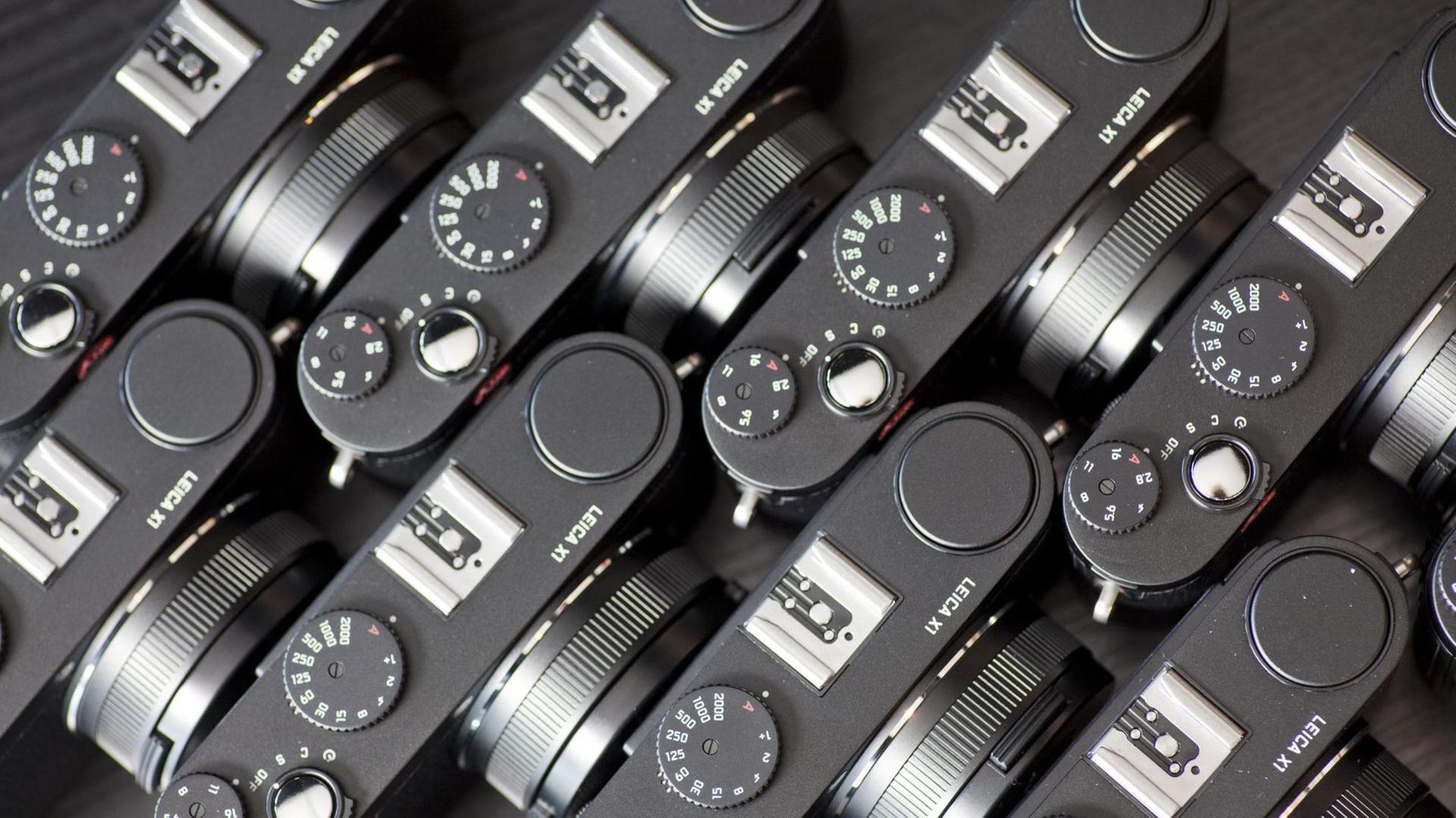 Das Foto zeiigt mehrere Leica Kameras von oben des Typs X1.
