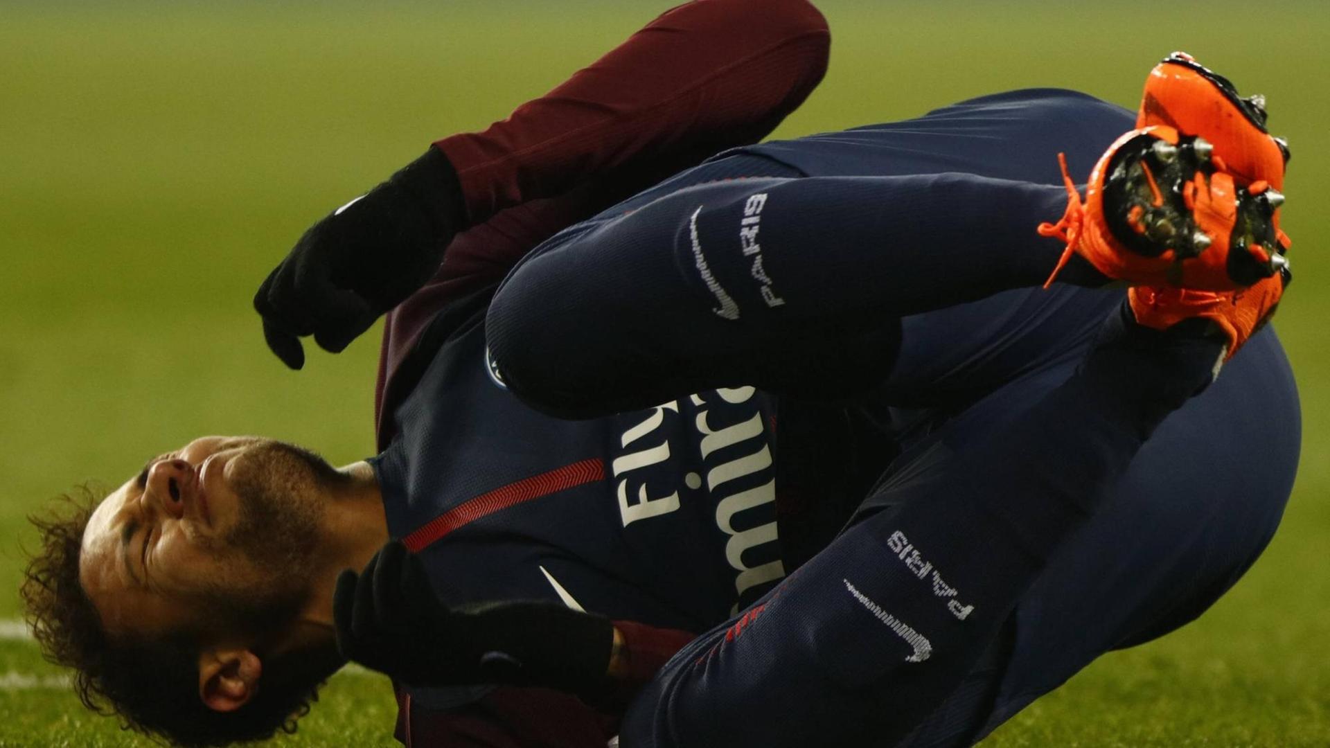Der Fußballspieler Neymar liegt verletzt am Boden Der Fußballspieler Neymar liegt verletzt am Boden
