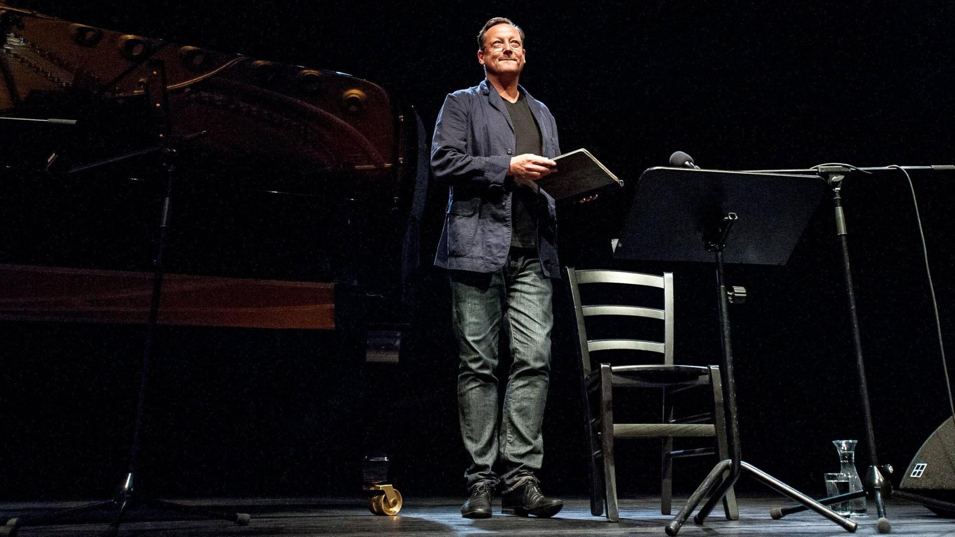 Auf einer Bühne verabschiedet sich der Schauspieler Matthias Brandt von seinem Publikum. Er trägt eine Jeans. Auf einer Bühne verabschiedet sich der Schauspieler Matthias Brandt von seinem Publikum. Er trägt eine Jeans.