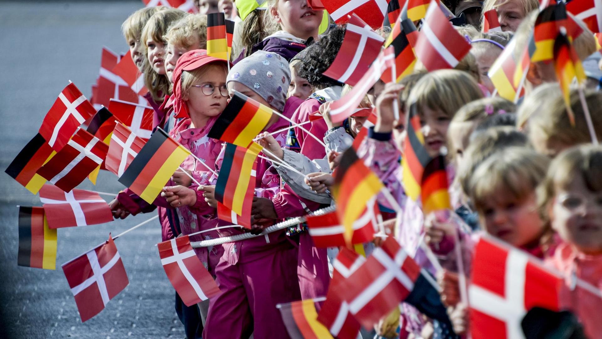 Schulkinder halten kleine deutsche und dänische Fahnen. Schulkinder halten kleine deutsche und dänische Fahnen.