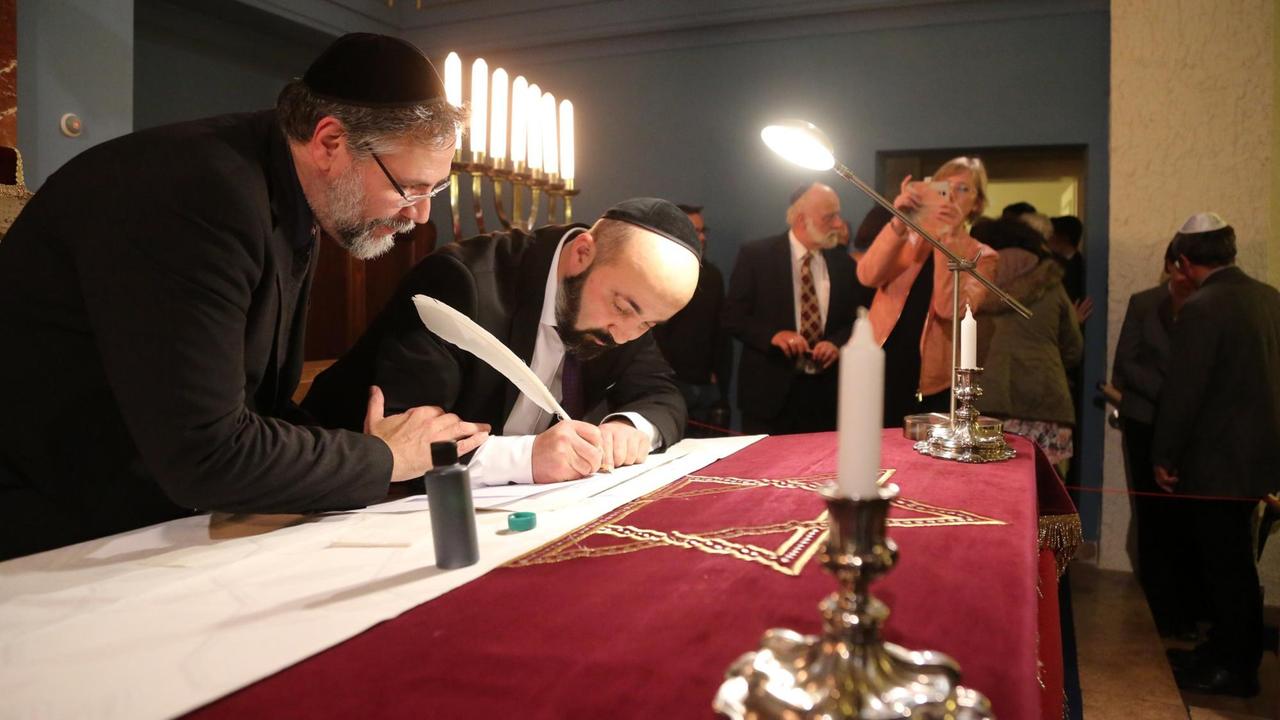 Erfurt - Schenkung einer Tora-Rolle 23.10.2019 , Erfurt, Neue Synagoge, die EKM und das Bistum Erfurt schenken der Jüdischen Landesgemeinde eine neue von Hand geschriebene Tora-Rolle, in einer selten stattfindenden Zeremonie wird der erste Buchstabe in der Erfurter Synagoge feierlich auf Pergament geschrieben im Bild: Sofer und Rabbiner Reuven Yaacobov aus Berlin schreibt mit einer Vogelfeder die ersten Buchstaben, hier mit einem Mitschreiber *** Erfurt Donation of a Tora Rolle 23 10 2019 , Erfurt, Neue Synagoge, the EKM and the diocese of Erfurt donate a new hand-written Tora Rolle to the Jewish community of Erfurt, in a rare ceremony the first letter in the Erfurt synagogue is solemnly written on parchment in the picture Sofer and Rabbi Reuven Yaacobov from Berlin writes the first letters with a birds feather, here with a clerk Erfurt - Schenkung einer Tora-Rolle 23.10.2019 , Erfurt, Neue Synagoge, die EKM und das Bistum Erfurt schenken der Jüdischen Landesgemeinde eine neue von Hand geschriebene Tora-Rolle, in einer selten stattfindenden Zeremonie wird der erste Buchstabe in der Erfurter Synagoge feierlich auf Pergament geschrieben im Bild: Sofer und Rabbiner Reuven Yaacobov aus Berlin schreibt mit einer Vogelfeder die ersten Buchstaben, hier mit einem Mitschreiber *** Erfurt Donation of a Tora Rolle 23 10 2019 , Erfurt, Neue Synagoge, the EKM and the diocese of Erfurt donate a new hand-written Tora Rolle to the Jewish community of Erfurt, in a rare ceremony the first letter in the Erfurt synagogue is solemnly written on parchment in the picture Sofer and Rabbi Reuven Yaacobov from Berlin writes the first letters with a birds feather, here with a clerk