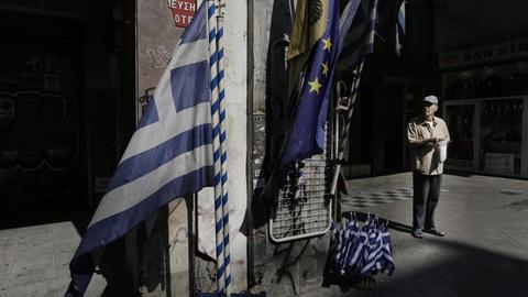 Griechische und europäische Fahnen vor einem Geschäft in Athen
