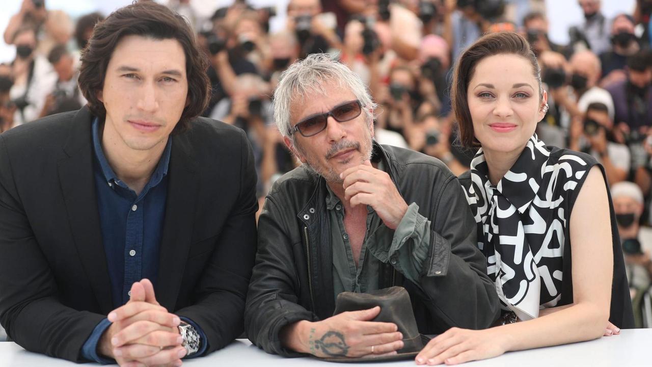 Der Regisseur Leos Carax mit seinen Hauptdarstellern Marion Cotillard und Adam Driver beim 74. Cannes International Film Festival. Der Regisseur Leos Carax mit seinen Hauptdarstellern Marion Cotillard und Adam Driver beim 74. Cannes International Film Festival.