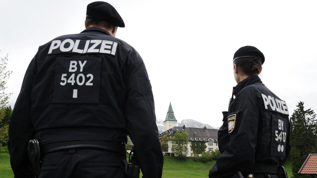 Zwei Polizisten stehen am 26.05.2015 in Elmau (Bayern) vor dem Schloss Elmau, wo vom 07. bis 08.06.2015 der G7-Gipfel stattfindet. In dem Fünf-Sterne-Hotel sind die letzten Urlaubsgäste abgereist, jetzt wird der Veranstaltungsort für das Treffen der Staats- und Regierungschefs der sieben führenden westlichen Industrienationen vorbereitet.