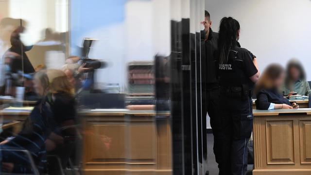 Justizbeamte und Journalisten warten im Landgericht Magdeburg auf den Beginn des Prozesses gegen den mutmaßlichen Attentäter von Halle.