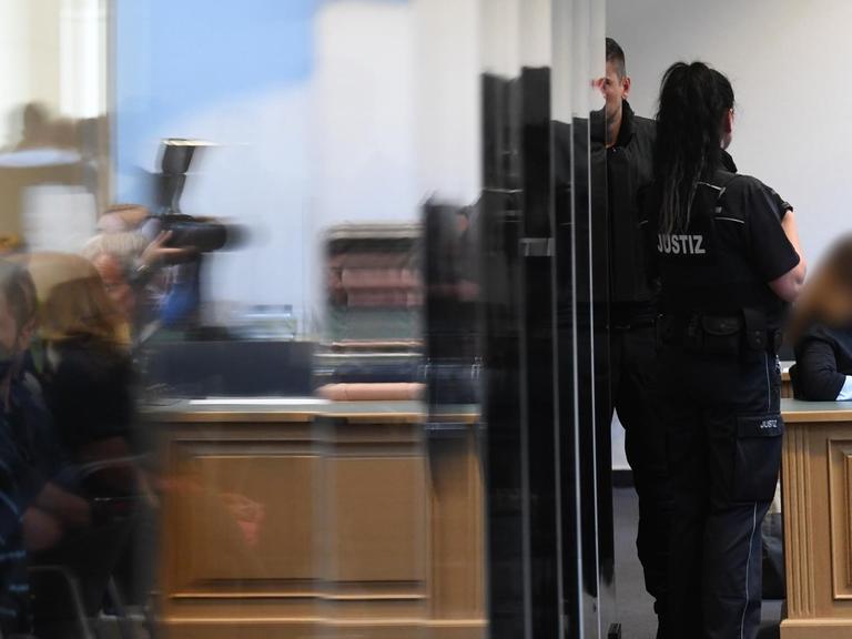 Justizbeamte und Journalisten warten im Landgericht Magdeburg auf den Beginn des Prozesses gegen den mutmaßlichen Attentäter von Halle.