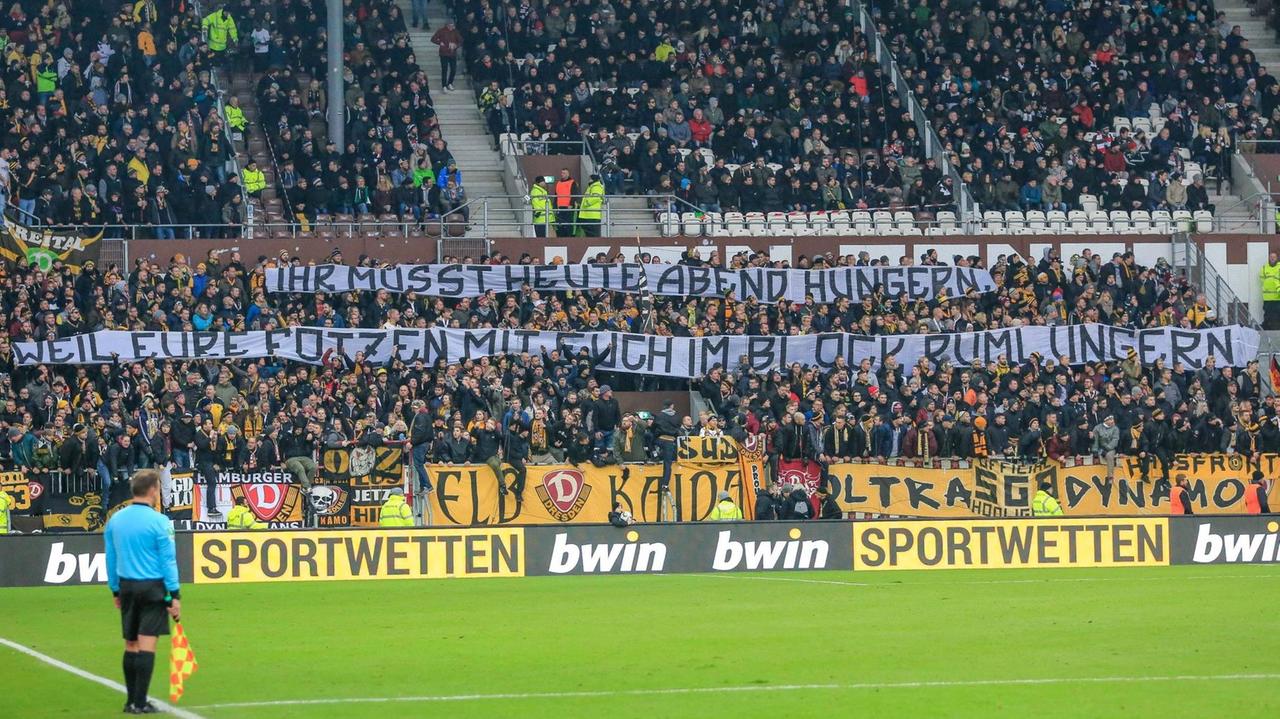 Dynamo Dresden Fans mit sexistischem Spruchband: Ihr müsst heute Abend hungern, weil eure Fotzen mit euch im Block rumlungern. Dynamo Dresden Fans mit sexistischem Spruchband: Ihr müsst heute Abend hungern, weil eure Fotzen mit euch im Block rumlungern.
