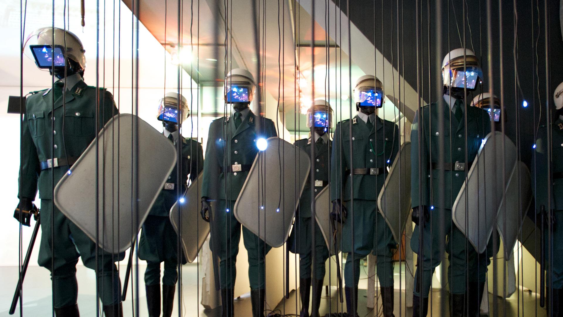 Figuren stehen als Polizisten mit Schlagstöcken und Schilden in Uniformen der Volkspolizei der ehemaligen Deutschen Demokratischen Republik (DDR) am 14.07.2013 in der Ausstellung "Moderne Zeiten" im Leipziger Alten Rathaus in Leipzig (Sachsen). Figuren stehen als Polizisten mit Schlagstöcken und Schilden in Uniformen der Volkspolizei der ehemaligen Deutschen Demokratischen Republik (DDR) am 14.07.2013 in der Ausstellung "Moderne Zeiten" im Leipziger Alten Rathaus in Leipzig (Sachsen).
