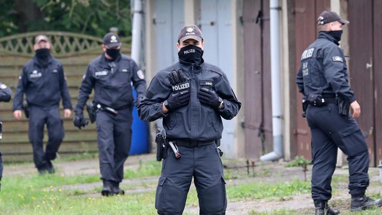 01.10.2020, Mecklenburg-Vorpommern, Löcknitz: Polizisten durchsuchen einen Garagenkomplex.