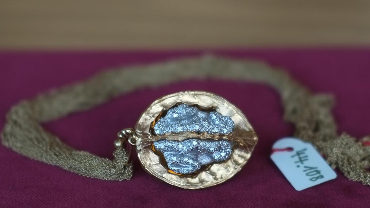eine vergoldete Walnuss, innen mit blau schimmernden Diamanten besetzt eine vergoldete Walnuss, innen mit blau schimmernden Diamanten besetzt