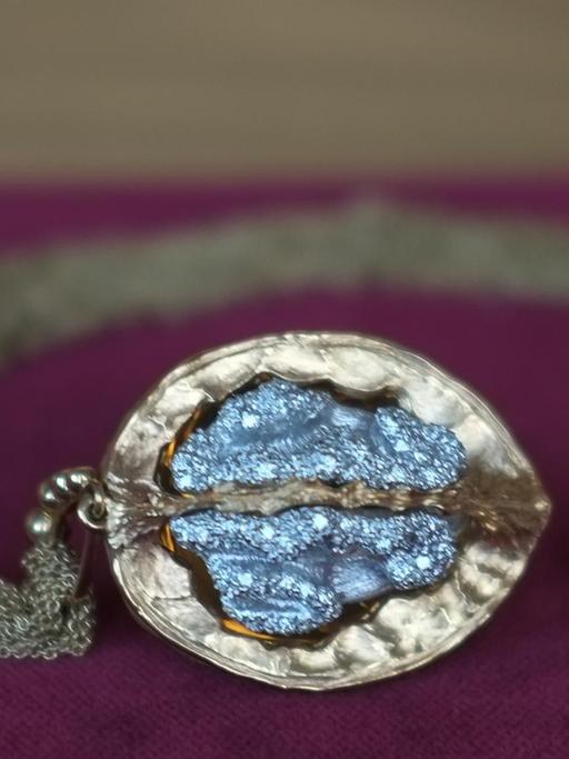 eine vergoldete Walnuss, innen mit blau schimmernden Diamanten besetzt