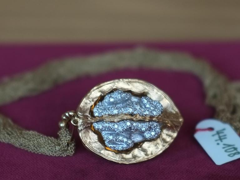 eine vergoldete Walnuss, innen mit blau schimmernden Diamanten besetzt