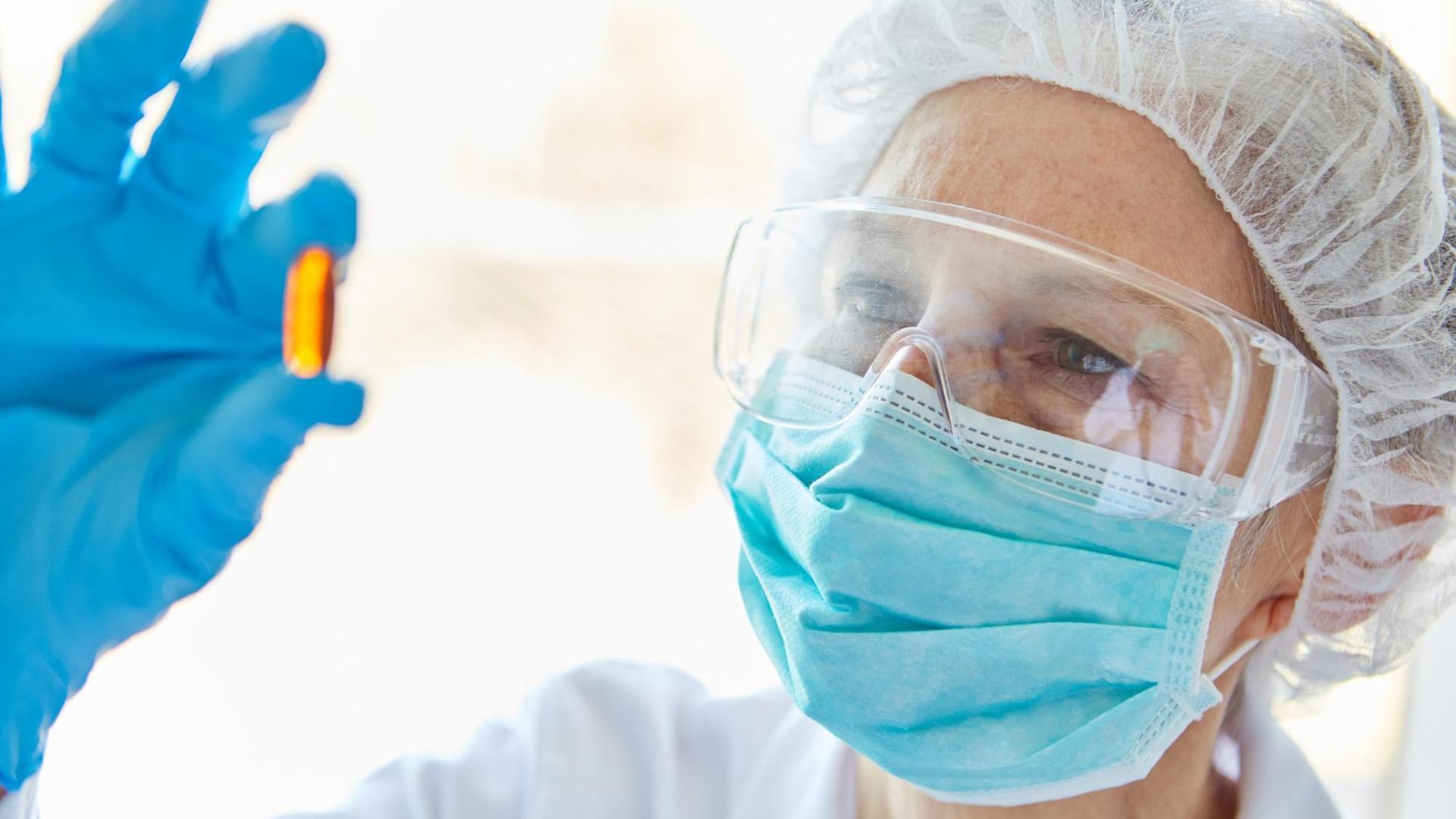 Forscher in Schutzkleidung arbeiten an einem Medikament gegen Covid-19 Forscher in Schutzkleidung arbeiten an einem Medikament gegen Covid-19