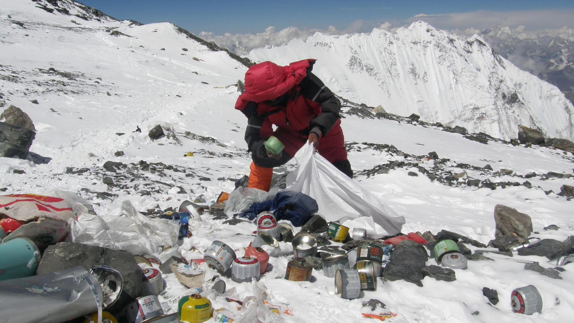 Ein nepalesischer Sherpa sammelt Müll von Bergsteigern am Mount Everest auf Ein nepalesischer Sherpa sammelt Müll von Bergsteigern am Mount Everest auf