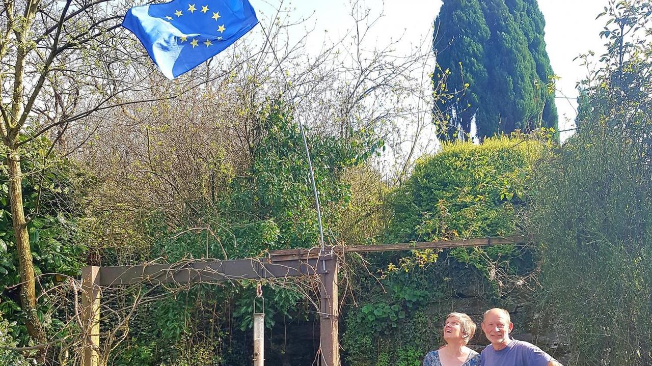 Die Waliser Judith und Iain mit ihrer blauen EU-Flagge im grünen Garten. Die Waliser Judith und Iain mit ihrer blauen EU-Flagge im grünen Garten.
