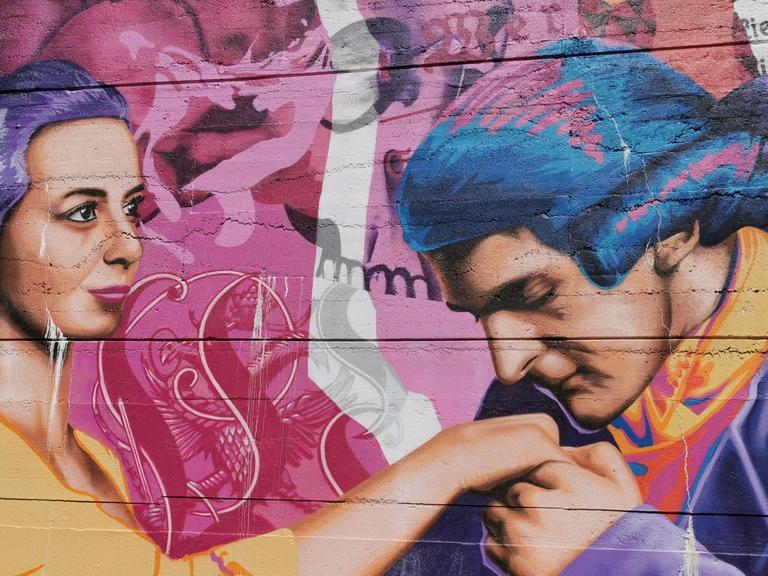 Christiane Spory steht vor einem Graffiti, das den jungen Goethe und Charltote Buff zeigt.