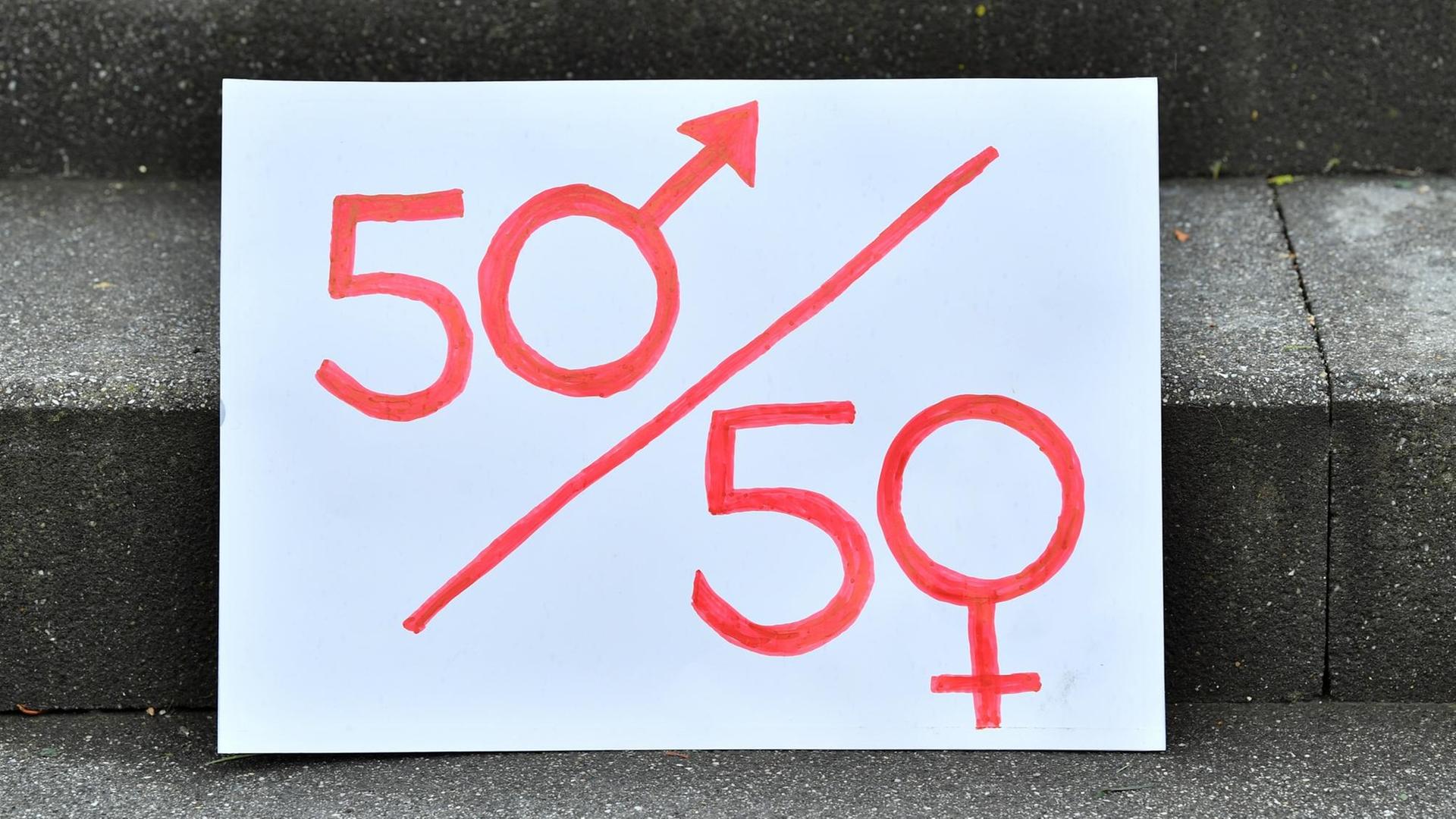 15.07.2020, Thüringen, Weimar: Ein Plakat mit einer symbolischen Darstellung der Parität steht am Rande einer Demonstration auf der Eingangstreppe vor Beginn der Urteilsverkündung im Thüringer Verfassungsgerichtshof. Parteien müssen in Thüringen ihre Kandidatenlisten für Landtagswahlen nicht abwechselnd mit Männern und Frauen besetzen. Das hat der Verfassungsgerichtshof entschieden und eine entsprechende Paritätsregelung im Landeswahlgesetz gekippt. Damit war eine Klage der AfD erfolgreich. Foto: Martin Schutt/dpa-Zentralbild/dpa | Verwendung weltweit