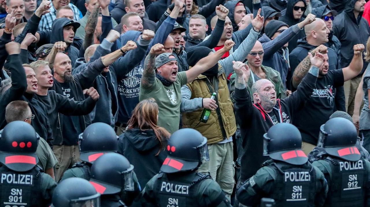 27. August 2018 in Chemnitz: Demonstranten der rechten Szene gestikulieren und drohen den Gegendemonstranten Gewalt an. 27. August 2018 in Chemnitz: Demonstranten der rechten Szene gestikulieren und drohen den Gegendemonstranten Gewalt an.
