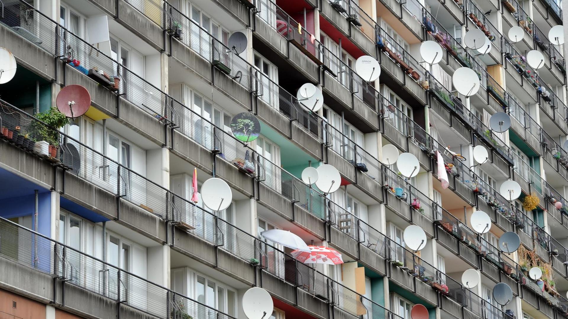 Die Ansicht einer Plattenbau-Häuserfront in Berlin mit Satelitenschüsseln an den Balkonen. Die Ansicht einer Plattenbau-Häuserfront in Berlin mit Satelitenschüsseln an den Balkonen.