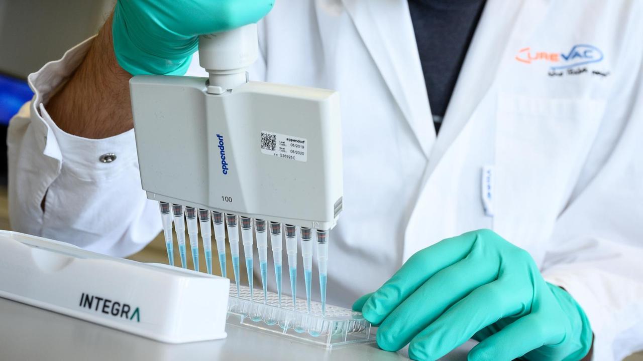 Ein Mann pipettiert in einem Labor des biopharmazeutischen Unternehmens Curevac eine blaue Flüssigkeit. Ein Mann pipettiert in einem Labor des biopharmazeutischen Unternehmens Curevac eine blaue Flüssigkeit.