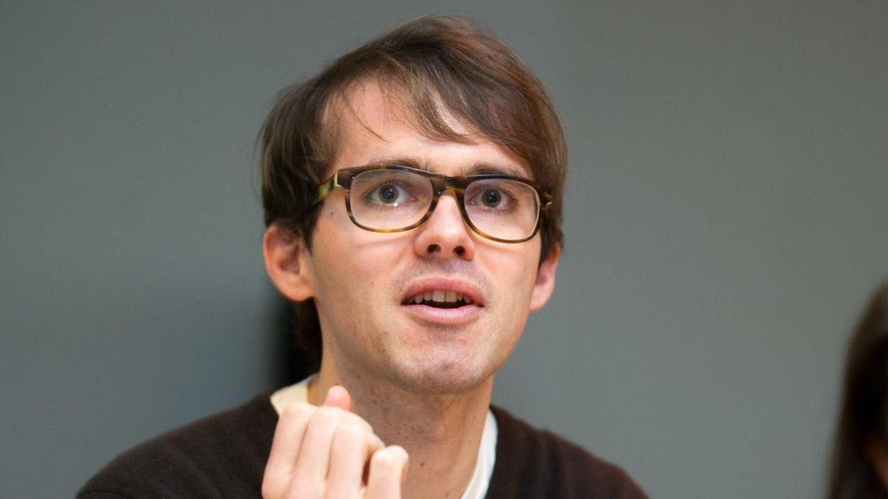 Sebastian Brünger (l); von 2006 bis 2015 Dramaturg im Theaterkollektiv "Rimini Protokoll" und Autor des Buches "Geschichte und Gewinn - Der Umgang deutscher Konzerne mit ihrer NS-Vergangenheit". Im Hintergrund ist Helgard Haug vom Rimini Protokoll zu sehen. Foto von 2013.
Sebastian Brünger (l); von 2006 bis 2015 Dramaturg im Theaterkollektiv "Rimini Protokoll" und Autor des Buches "Geschichte und Gewinn - Der Umgang deutscher Konzerne mit ihrer NS-Vergangenheit". Im Hintergrund ist Helgard Haug vom Rimini Protokoll zu sehen. Foto von 2013.