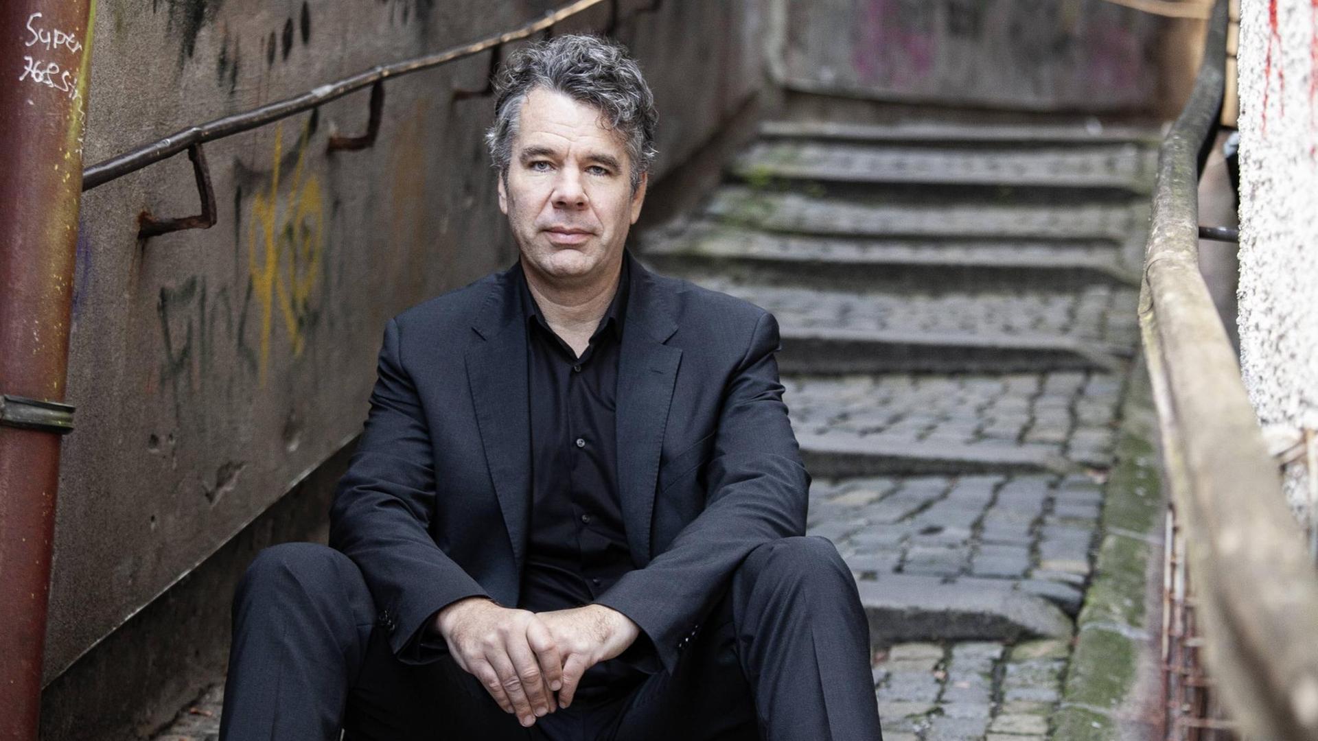 Thomas Galli auf einer Treppe sitzend. Thomas Galli auf einer Treppe sitzend.