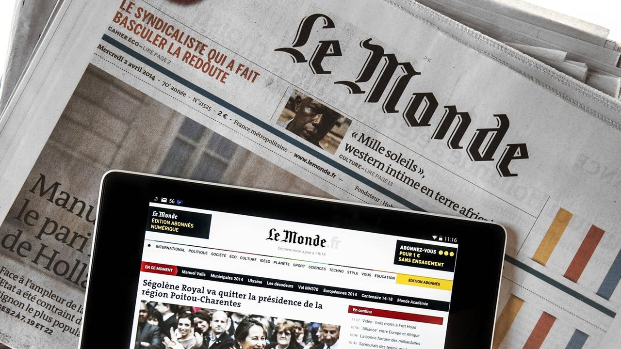 Das Touchscreen eines digitalen Tablets zeigt online Nachrichten, welches auf der französischen Zeitung "Le Monde" liegt. Das Touchscreen eines digitalen Tablets zeigt online Nachrichten, welches auf der französischen Zeitung "Le Monde" liegt.