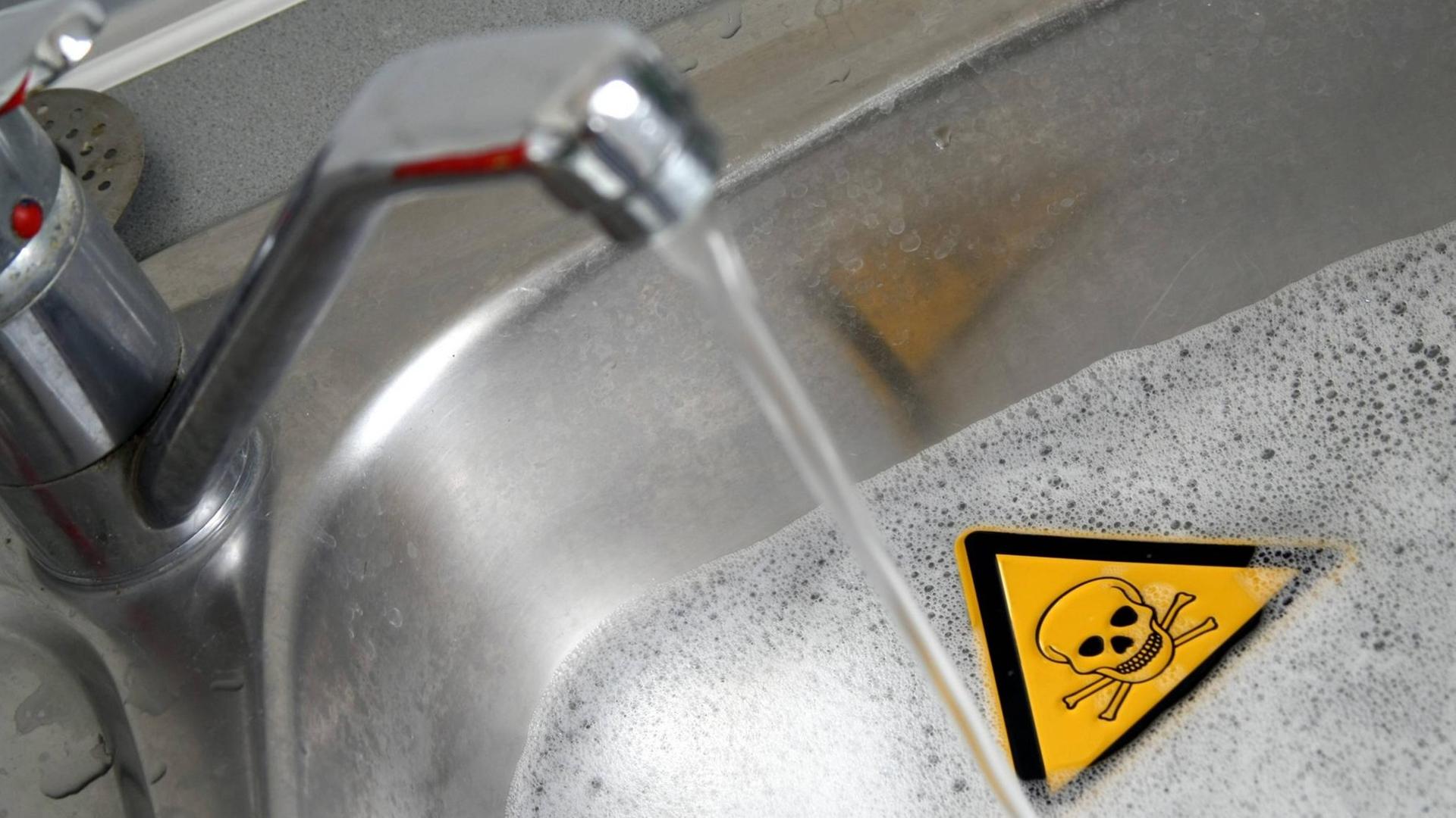 Symbolbild für Gefahren im Haushalt: Warnschild Achtung Gift in einer mit Wasser und Reinigungsmittel gefüllten Spüle in der Küche sowie Wasserhahn Symbolbild für Gefahren im Haushalt: Warnschild Achtung Gift in einer mit Wasser und Reinigungsmittel gefüllten Spüle in der Küche sowie Wasserhahn
