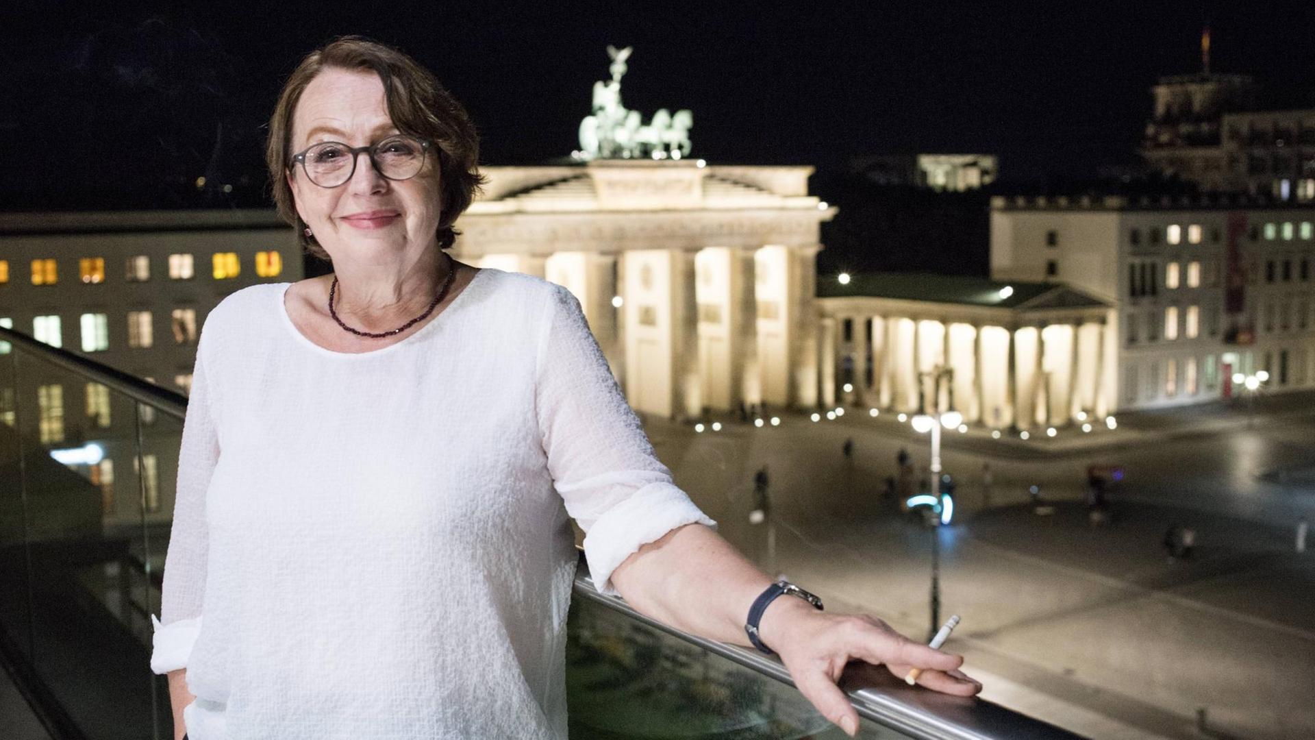 Die Autorin mit Brille an ein Geländer gelehnt vor dem Brandenburger Tor. Sie schaut in die Kamera Berliner Akademie der Künste Katja Lange-Müller "Drehtür", Verlag Kiepenheuer & Witsch Buchpremiere in der Berliner Akademie der Künste Begrüßung: Friedrich Christian Delius Einführung und Gespräch: Denis Scheck am Dienstag, 30.8.2016 Die Autorin mit Brille an ein Geländer gelehnt vor dem Brandenburger Tor. Sie schaut in die Kamera Berliner Akademie der Künste Katja Lange-Müller "Drehtür", Verlag Kiepenheuer & Witsch Buchpremiere in der Berliner Akademie der Künste Begrüßung: Friedrich Christian Delius Einführung und Gespräch: Denis Scheck am Dienstag, 30.8.2016