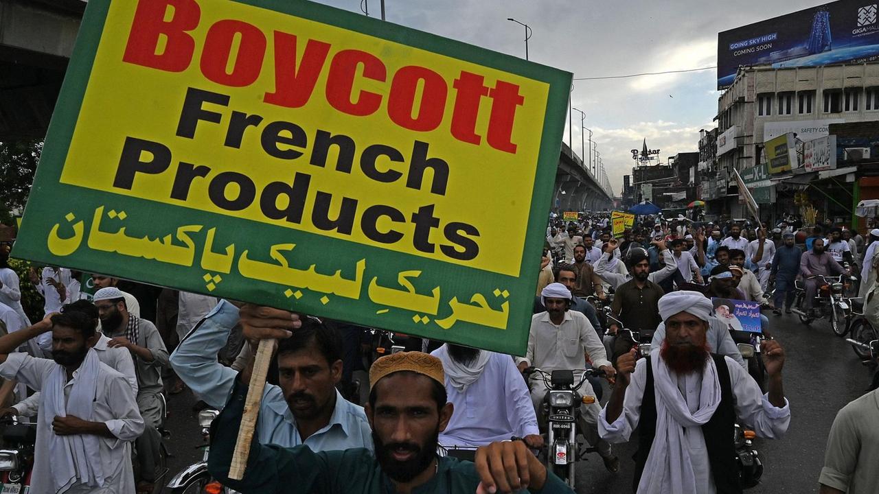 Unterstützer der islamistischen Partei Tehreek-e-Labbaik skandieren und halten ein Schild hoch mit der Aufschrift "Boycott French Products" ("Boykottiert französische Produkte")