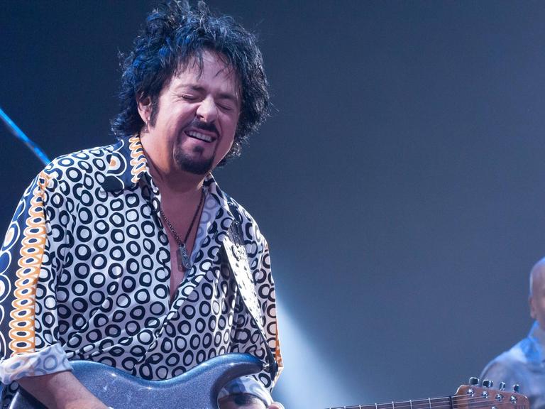 Der Musiker Steve Lukather spielt auf einer Gitarre.