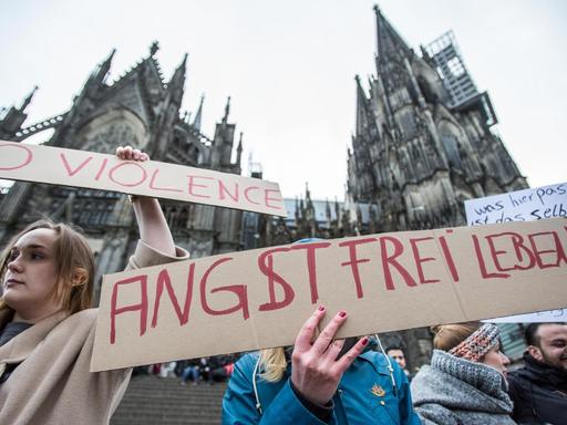 Eine Frau protestiert am 10.01.2016 in Köln vor dem Hauptbahnhof und dem Dom gegen sexuelle Gewalt mit einem Plakat "Angstfrei leben".