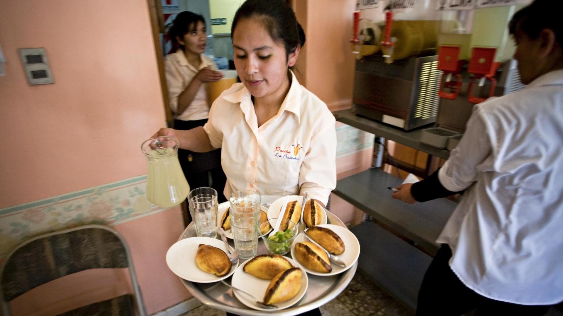 A picture dated 28 August 2008 shows a young woman working in a restaurant in La Paz, Bolivia. More than one third of Latin American women do not have income of their own according to a report of the Economic Commission for Latin America (ECLAC). PATRICIO CROOKER/dpa | Verwendung weltweit