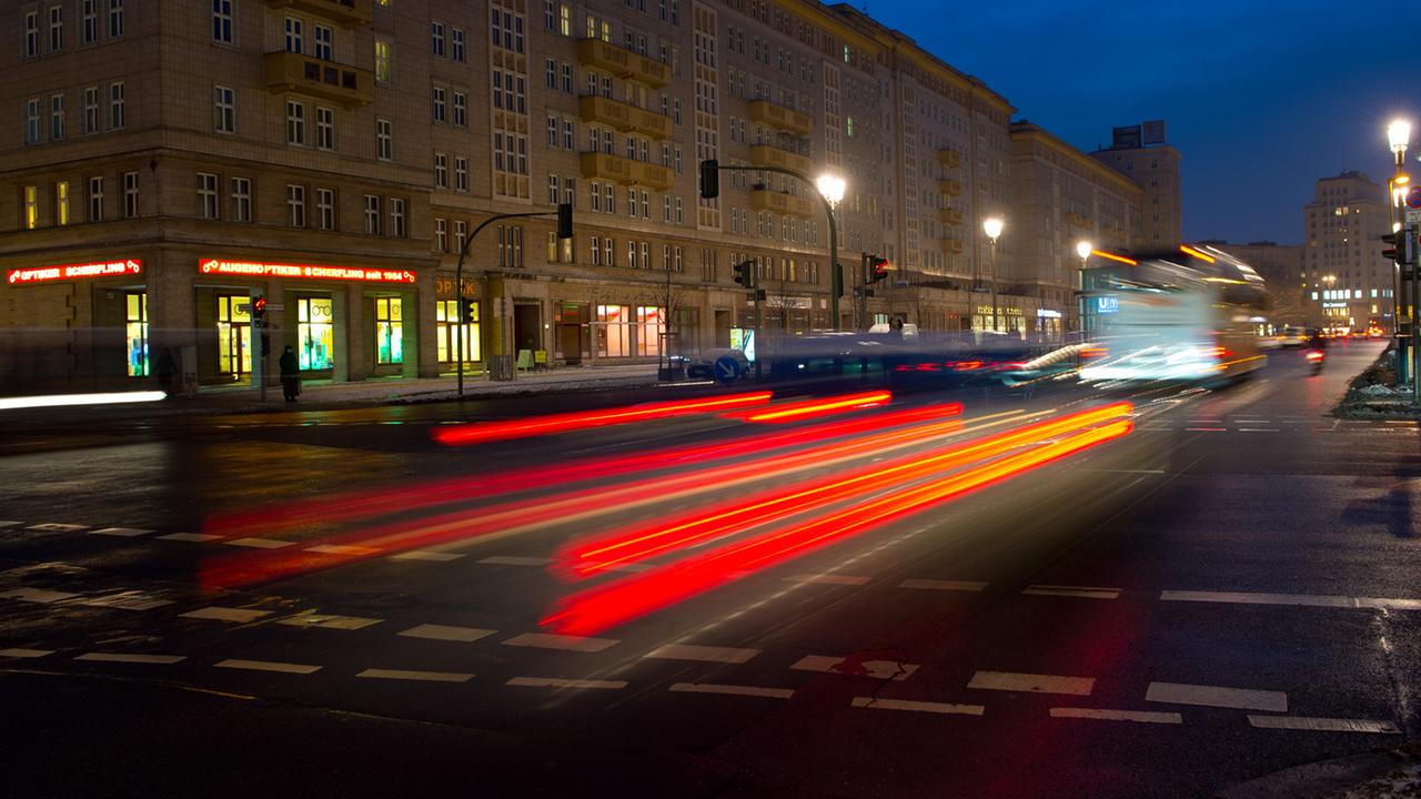 Die Rücklichter eines fahrenden Autos auf der Karl-Marx-Allee in Berlin.
