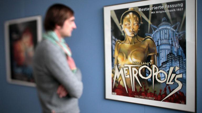 Ein Mann schaut sich am Freitag (29.01.2010) in der Friedrich-Wilhelm-Murnau-Stiftung in Wiesbaden ein altes Filmplakat des Films "Metropolis" an.
