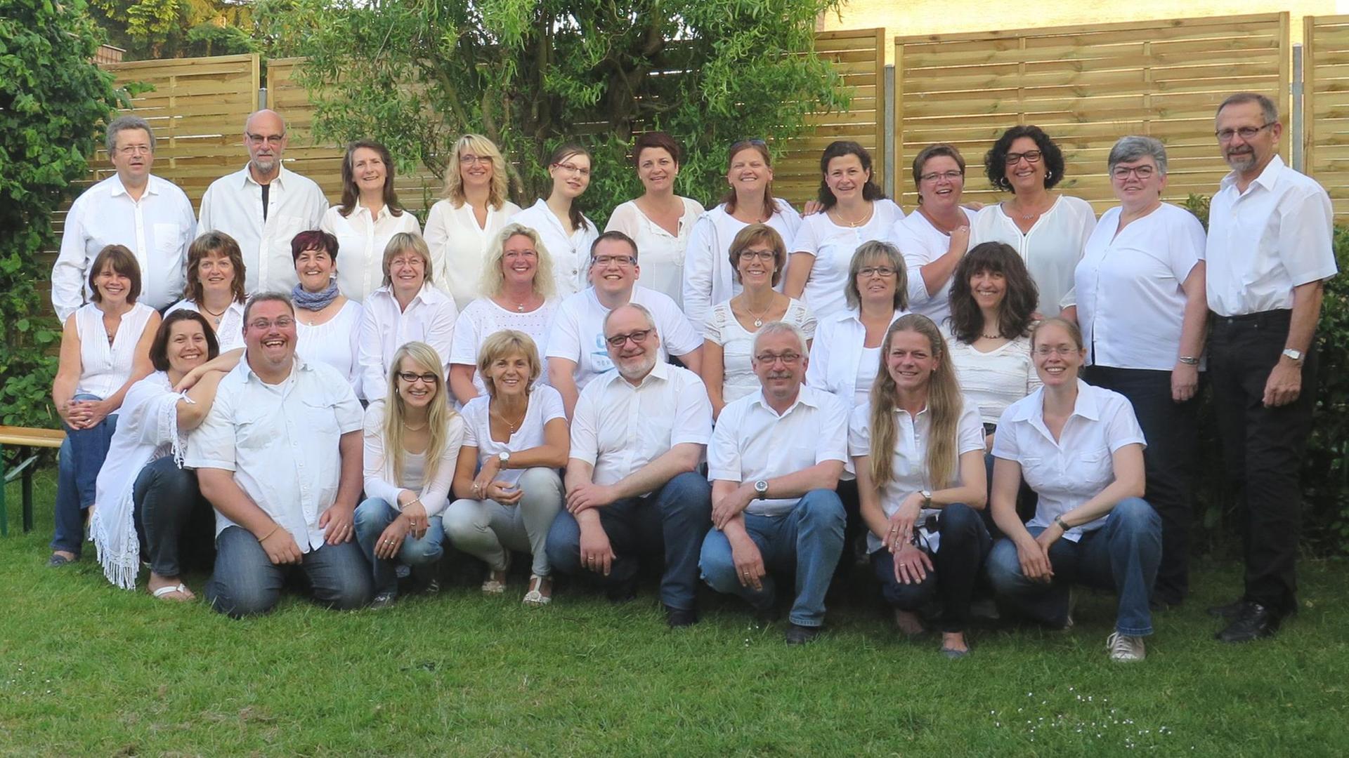 Ein Gruppenbild des Chores. Alle tragen blaue Jeans und weiße Hemden. Ein Gruppenbild des Chores. Alle tragen blaue Jeans und weiße Hemden.