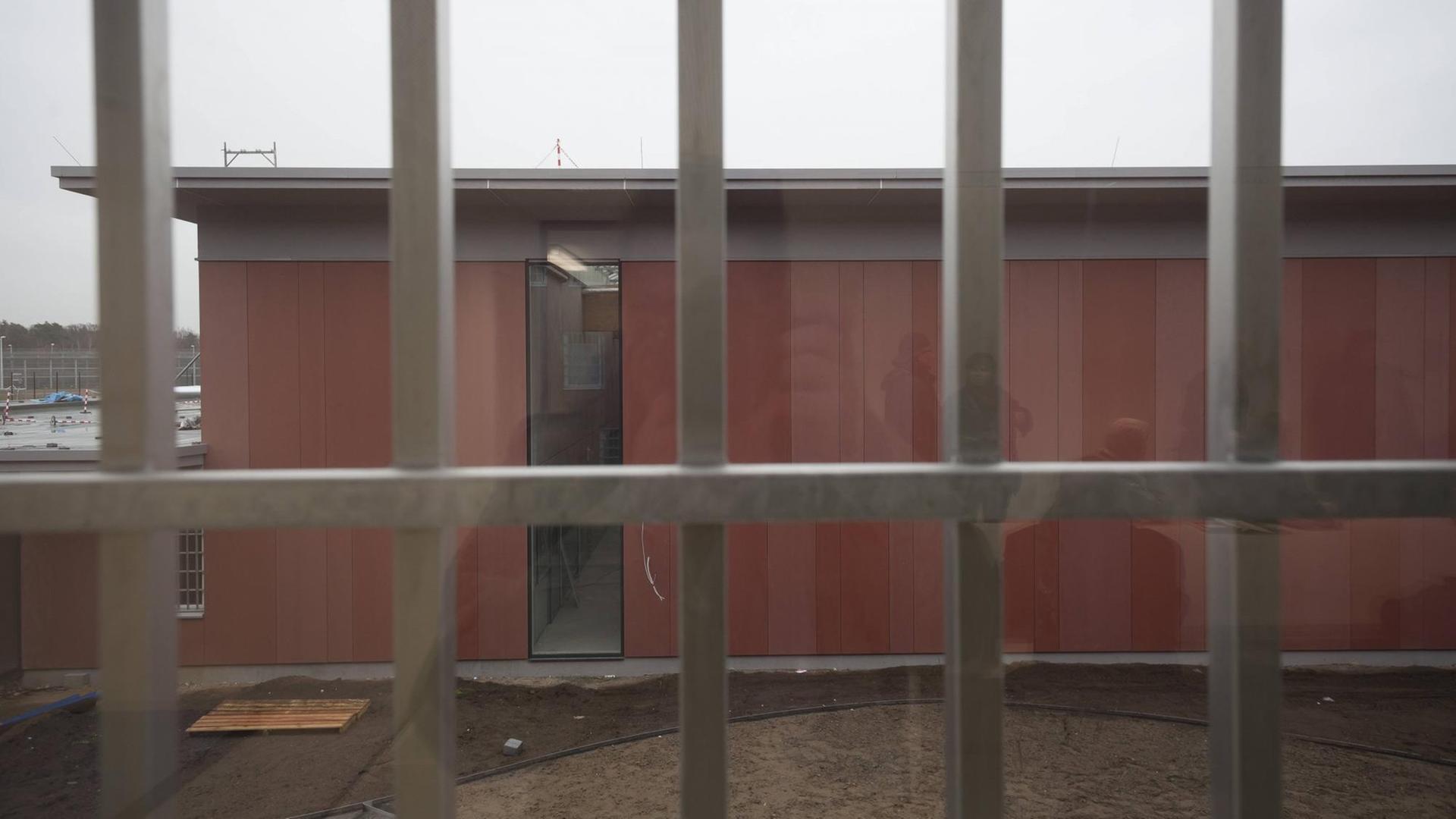 Ein Blick durch ein vergittertes Fenster in der Justizvollzugsanstalt Heidering während des Baus des Gefängnisses.