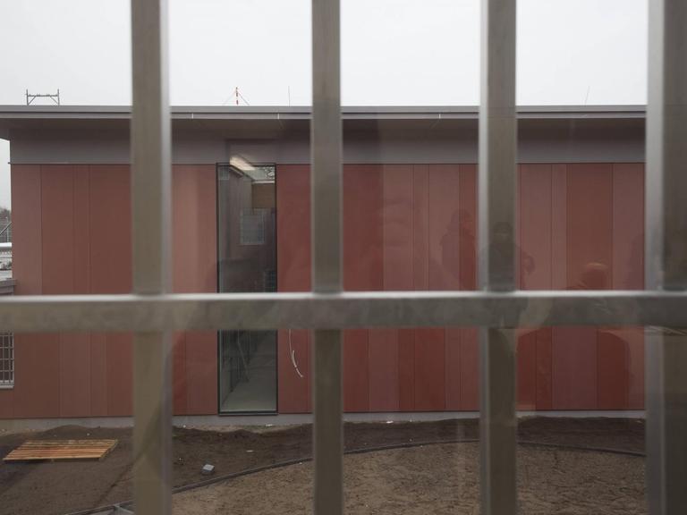 Ein Blick durch ein vergittertes Fenster in der Justizvollzugsanstalt Heidering während des Baus des Gefängnisses.