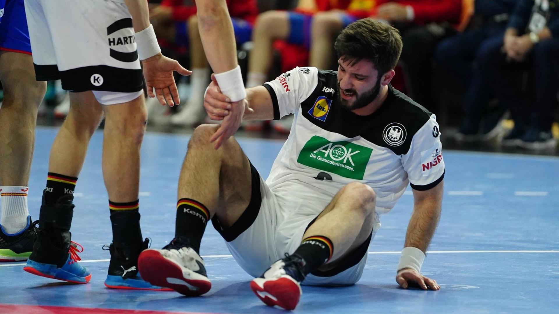 Der deutsche Handball-Nationalspieler Tim Suton sitzt verletzt am Boden