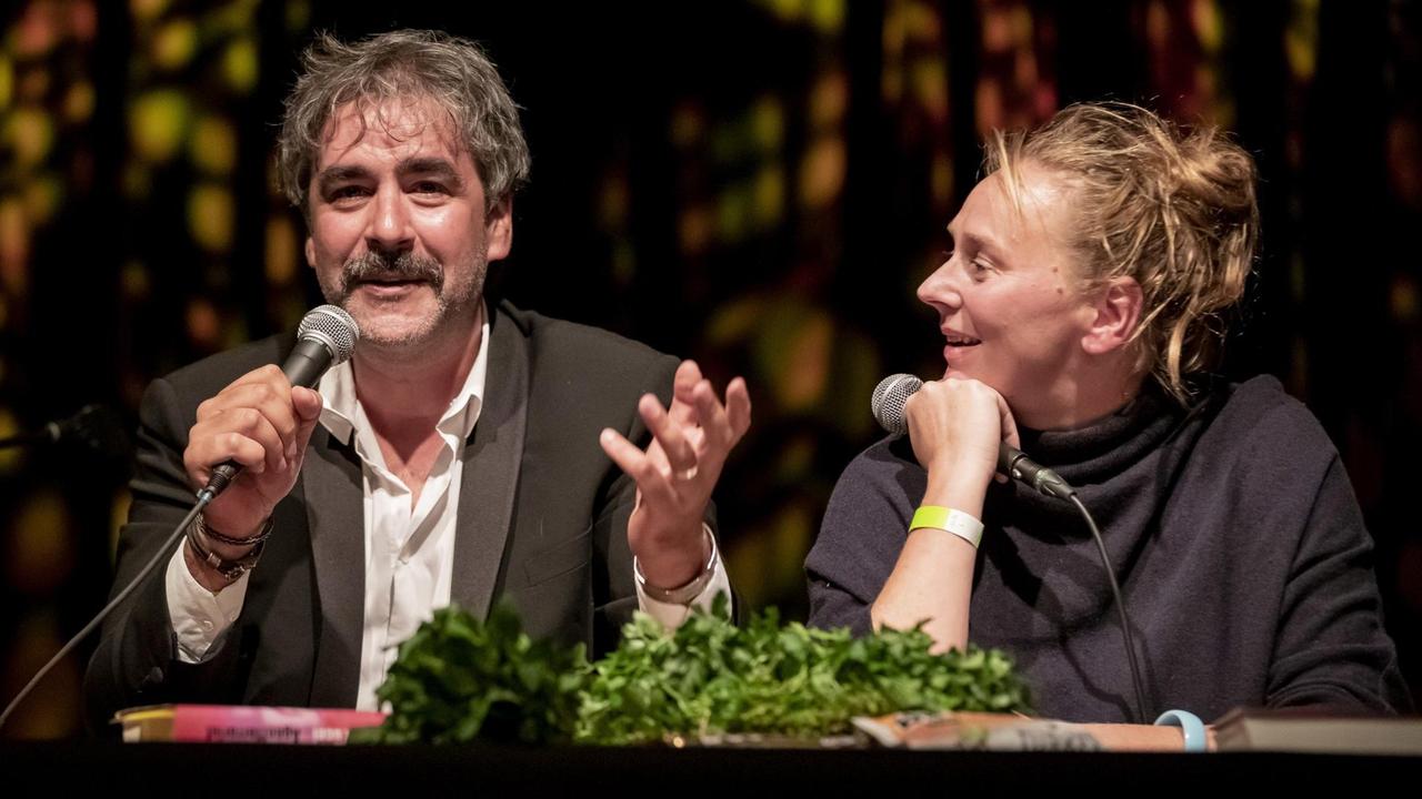 Deniz Yücel und Doris Akrap sitzen auf dem Podium im Festsaal Kreuzberg während der Buchpremiere. Deniz Yücel und Doris Akrap sitzen auf dem Podium im Festsaal Kreuzberg während der Buchpremiere.