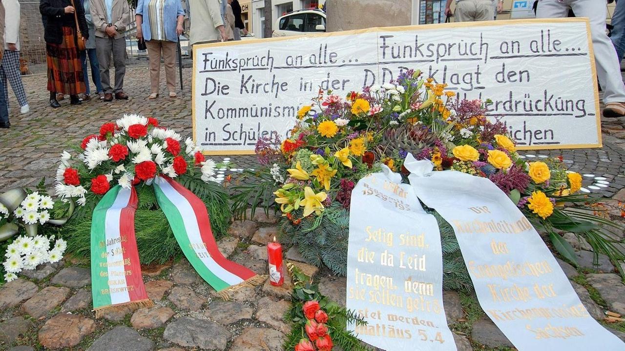 An die öffentliche Selbstverbrennung des Pfarrers Oskar Brüsewitz vor 30 Jahren haben rund 400 Menschen am 18.08.06 in Zeitz (Sachsen-Anhalt) mit einem Gottesdienst erinnert. Nach dem Gottesdienst legten Vertreter der Kirchenleitung sowie Verwandte, Freunde und Weggefährten Kränze an der Brüsewitz-Gedenksäule vor der Kirche nieder. An die öffentliche Selbstverbrennung des Pfarrers Oskar Brüsewitz vor 30 Jahren haben rund 400 Menschen am 18.08.06 in Zeitz (Sachsen-Anhalt) mit einem Gottesdienst erinnert. Nach dem Gottesdienst legten Vertreter der Kirchenleitung sowie Verwandte, Freunde und Weggefährten Kränze an der Brüsewitz-Gedenksäule vor der Kirche nieder.