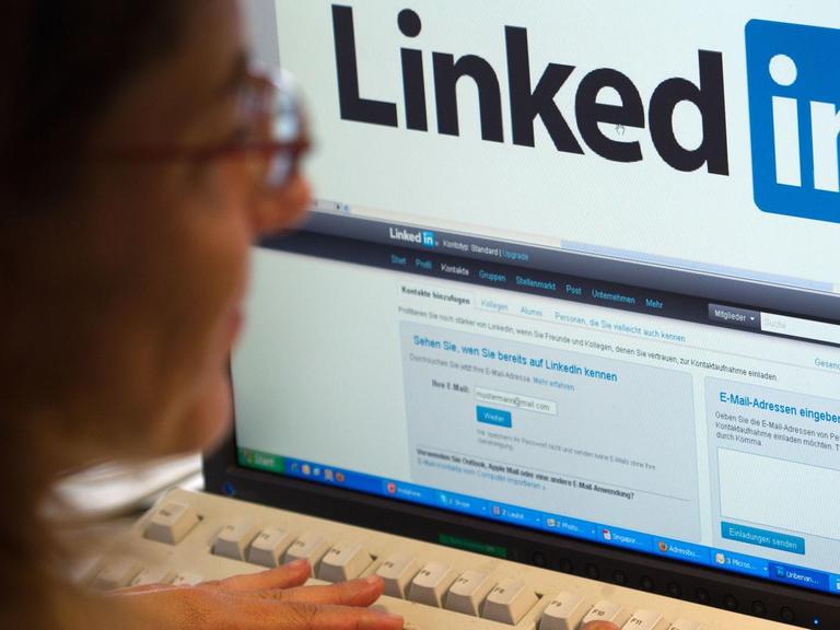 Ein Frau arbeitet an einem Computer mit dem Online-Netzwerk LinkedIn