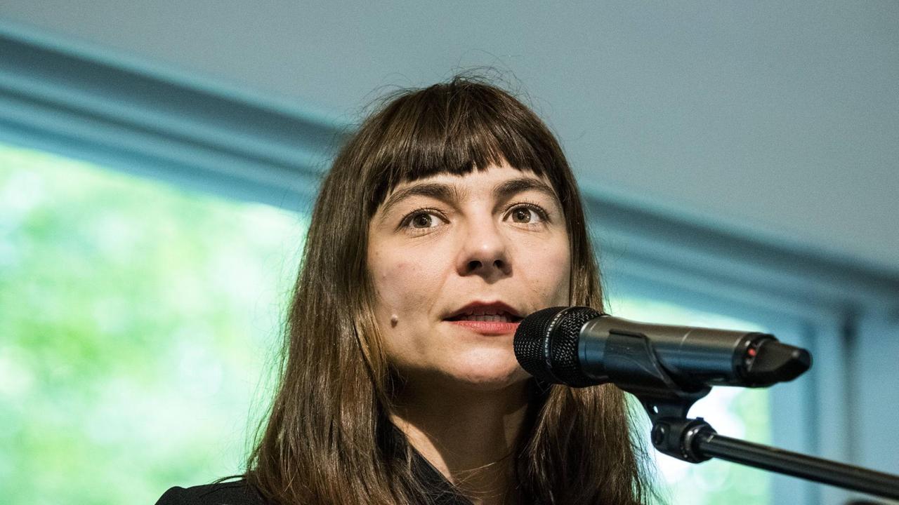 Uljana Wolf während einer Lesung, vor dem Mikrofon. Uljana Wolf während einer Lesung, vor dem Mikrofon.