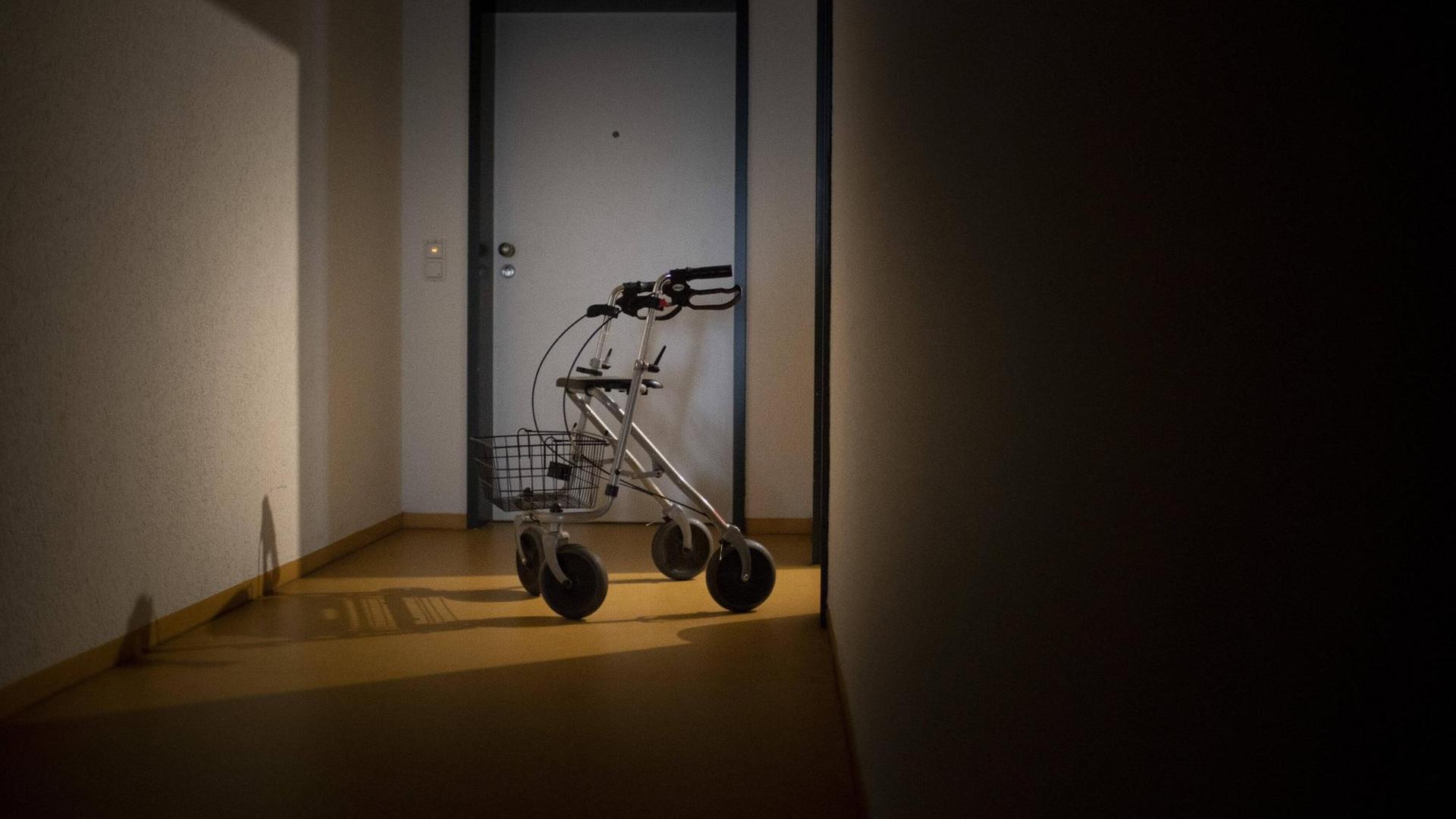 Ein Rollator auf einem Flur. Im Hintergrund eine Tür. Ein Rollator auf einem Flur. Im Hintergrund eine Tür.