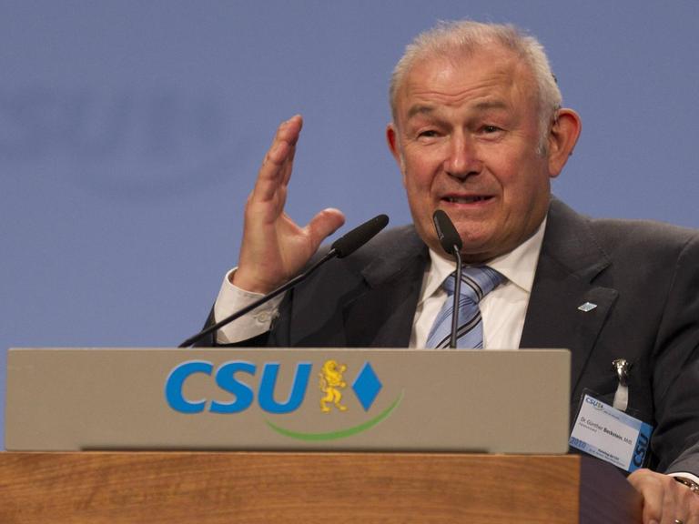 Günther Beckstein, früherer bayerischer Ministerpräsident, steht an einem Pult und hält eine Rede.