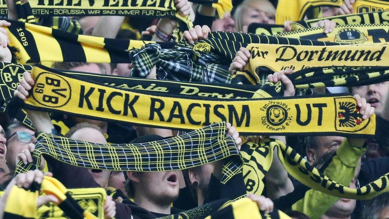 Ein Dortmund-Fan hält einen Anti-Rassismus-Schal im Fan-Block von Borussia Dortmund Borussia Dortmund hoch. Ein Dortmund-Fan hält einen Anti-Rassismus-Schal im Fan-Block von Borussia Dortmund Borussia Dortmund hoch.