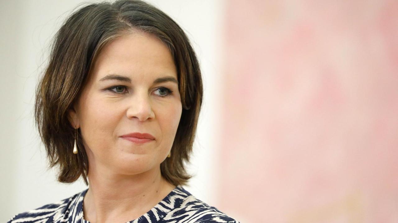 Außenministerin Annalena Baerbock steht vor einer rosa-weißen Wand. Außenministerin Annalena Baerbock steht vor einer rosa-weißen Wand.